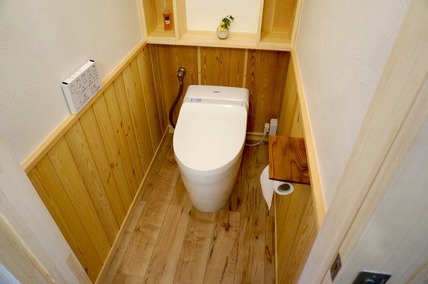  マンションのトイレリフォーム　腰壁に無垢の赤松材と背面収納カウンター　タンクレストイレ