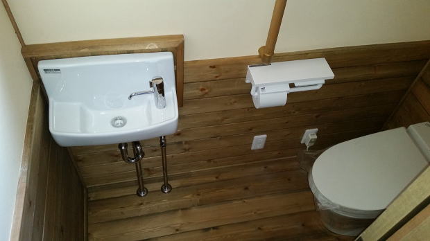 トイレの手洗器と無垢の床材に腰壁材は赤松材で　所沢市トイレ事例写真