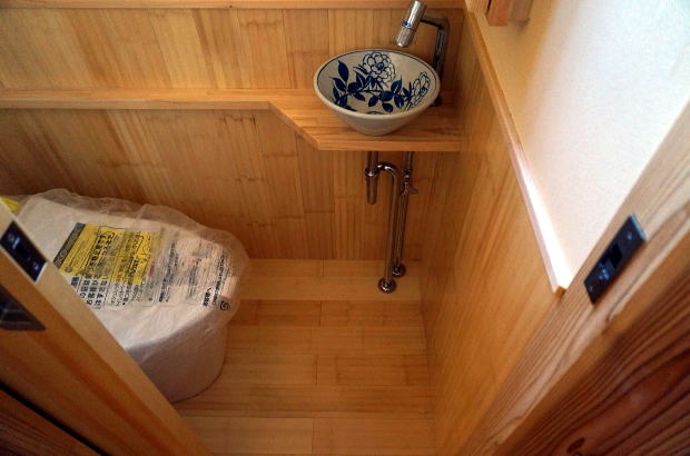 トイレの床と腰壁は竹材、手洗いカウンターに陶器のボウル