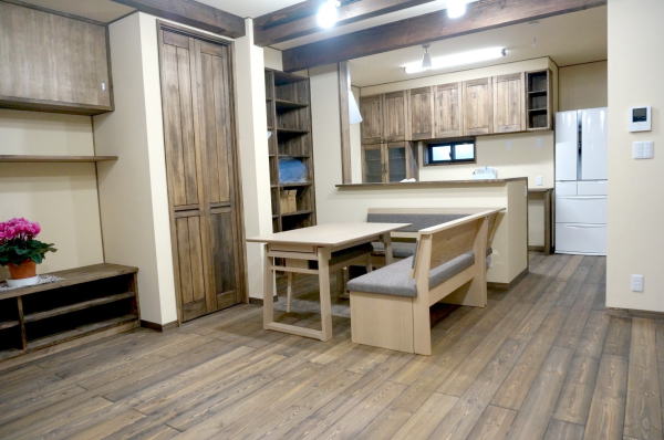 対面キッチンダイニング側床は赤松無垢フロアに植物系ワックスで着色。天然木の食器棚も同色で